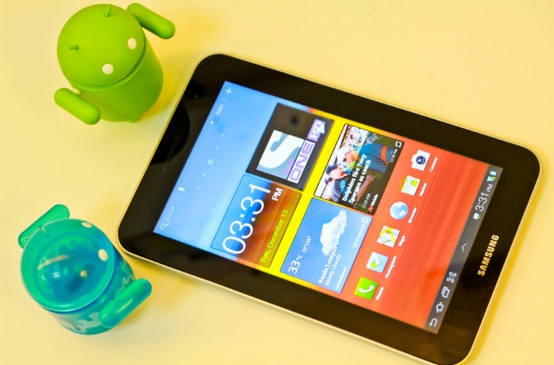 A Samsung tablet with two Android mascots.