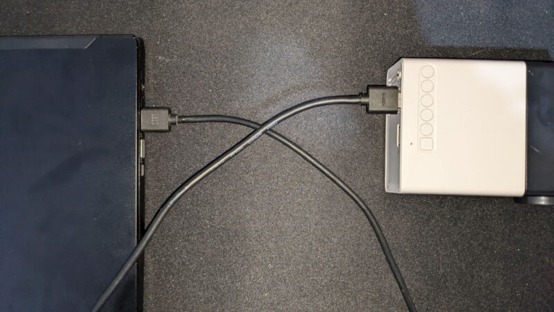 A photograph showing a projector properly connected to a laptop.