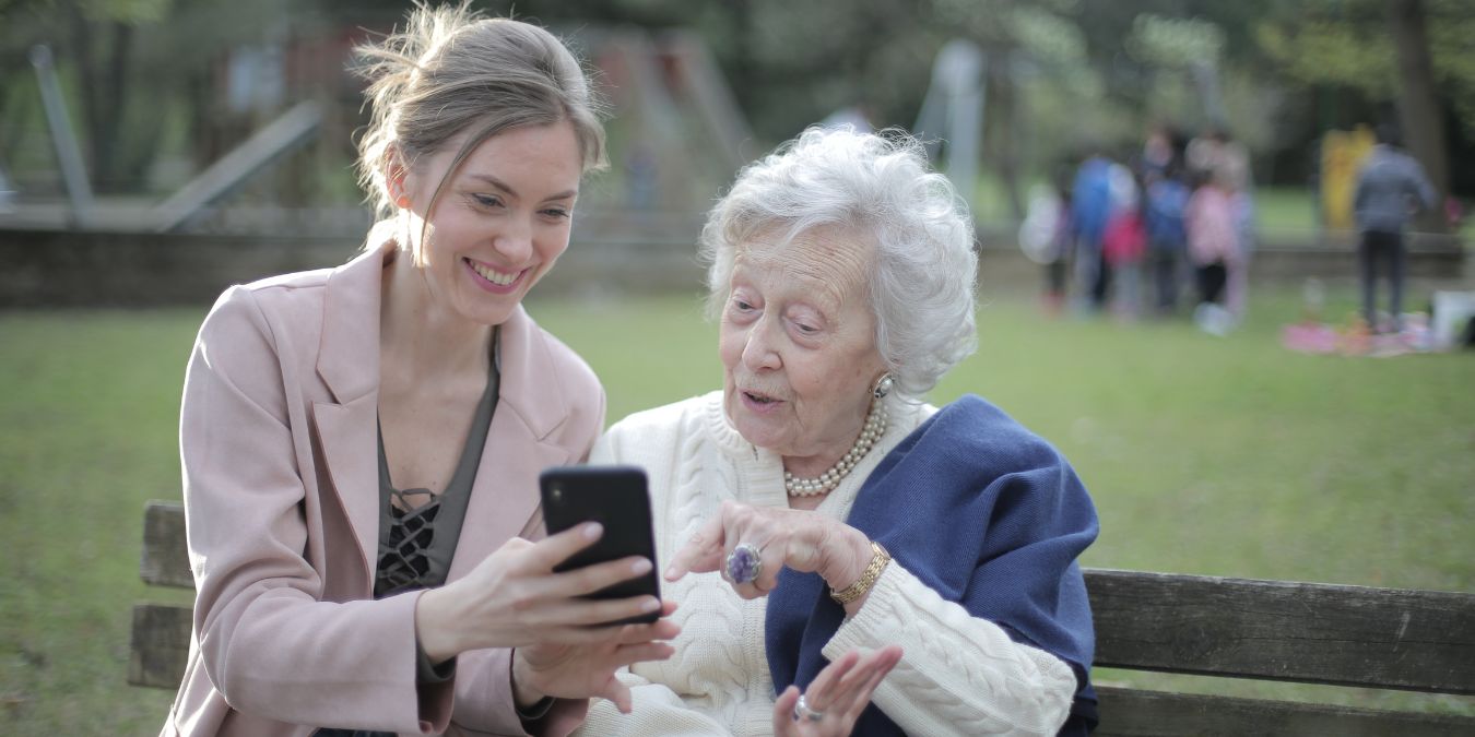 Young Lady And Female Older Adult Using An Iphone